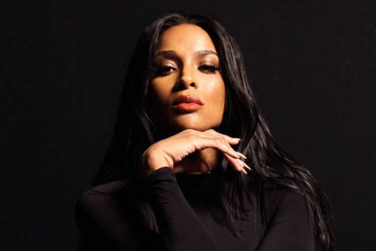 A photo of Ciara wearing black against black background