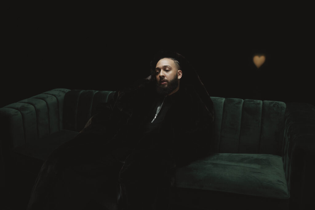Isaiah Falls sitting on a green couch