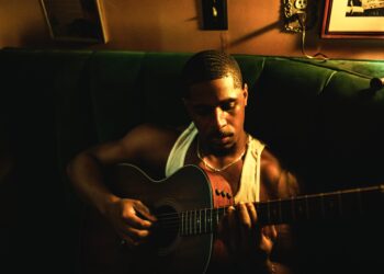 R&B singer Khamari holding a guitar