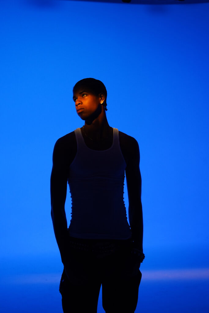 A photo of R&B singer JayDon standing in front of a blue backdrop