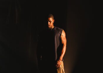 Khamari stands outside in the dark