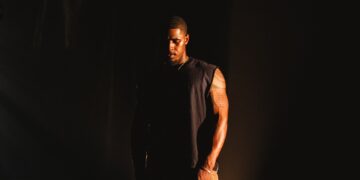 Khamari stands outside in the dark