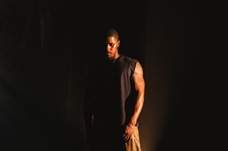 Khamari stands outside in the dark
