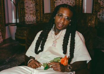 A photo of Jacquees holding a flower